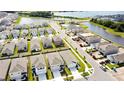 Aerial view of a community with houses, a lake, and a pool at 12113 Water Ash Pl, Riverview, FL 33569