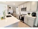 Modern kitchen featuring stainless steel appliances, gray cabinets, and white quartz countertops at 12113 Water Ash Pl, Riverview, FL 33569