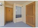 Welcoming entrance featuring a wooden door, small window, and neutral color palette at 16308 Gulf Blvd # 303, Redington Beach, FL 33708