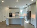 Modern kitchen with island, stainless steel appliances, and white cabinets at 5633 Clearwater Ct, Lakewood Ranch, FL 34211