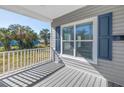 Inviting front porch features gray wood-look flooring and a view of the greenery across the street at 719 19Th S St, St Petersburg, FL 33712