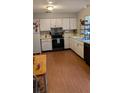 Bright kitchen with wood-look floors, white cabinets, and modern appliances at 21373 Lincoln Rd, Brooksville, FL 34601