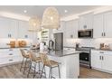 Modern white kitchen with gray countertops, stainless steel appliances, and an island at 31464 Woodland Race Loop, Wesley Chapel, FL 33545