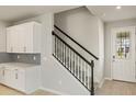 Modern staircase with white cabinets and gray tile at 31464 Woodland Race Loop, Wesley Chapel, FL 33545