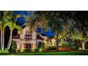 Charming stone home with lush landscaping at night at 118 Harbor View Ln, Belleair Bluffs, FL 33770