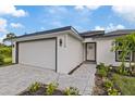 Modern home exterior featuring a paved walkway and partial view of landscaping at 12114 Clarendon Ave, Port Charlotte, FL 33981