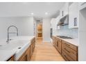 Bright kitchen with a farmhouse sink, stainless steel appliances, ample cabinet space, and a tile backsplash at 2311 Overfalls Pl, Wesley Chapel, FL 33543