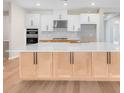 Beautiful kitchen featuring white and wood cabinetry, a large island, stainless steel appliances, and a tile backsplash at 2311 Overfalls Pl, Wesley Chapel, FL 33543