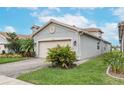 Gray house with a two-car garage and nicely landscaped yard at 4735 Avila Lakes Dr, Wimauma, FL 33598