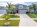 Two-story house with gray siding, stone accents, and a landscaped lawn at 11411 Alachua Creek Ln, Riverview, FL 33579