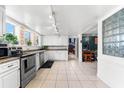 Updated kitchen boasts white cabinets, stainless steel appliances, and tile floors at 7424 Lance St, Zephyrhills, FL 33541