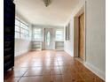 Bright sunroom featuring tile floors, built-in shelving, and a charming entry door at 7424 Lance St, Zephyrhills, FL 33541