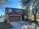 Two-story house with brown exterior, attached garage, and landscaping at 12705 Longcrest Dr, Riverview, FL 33579