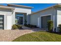 Front entry with modern double doors and landscaping at 9028 Ivy Stark Blvd, Wesley Chapel, FL 33545