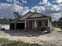 Exterior of an under construction single story home with brick and tyvek exterior and an attached garage at 413 Shannon Estates Ct, Plant City, FL 33563