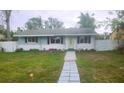 Newly renovated light blue and white bungalow with a walkway and fenced yard at 920 Hull S St, Gulfport, FL 33707