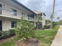 Exterior of condo building with landscaping and walkway at 208 Nina Way # 208, Oldsmar, FL 34677