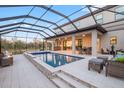 Luxury pool and spa with covered patio and lounge area at 13019 Paddock Wood Pl, Riverview, FL 33579
