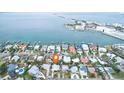 Aerial view of waterfront homes with boat docks, offering stunning views of the bay and bridge at 2456 Tradewinds Dr, Dunedin, FL 34698