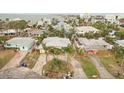 Aerial view of a home with a circular driveway near the water, showcasing surrounding neighborhood and bay at 2456 Tradewinds Dr, Dunedin, FL 34698