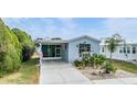 Gray mobile home with covered porch and landscaped yard at 3836 Chris Dr, Wesley Chapel, FL 33543