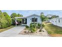 Mobile home with covered porch and nicely landscaped yard at 3836 Chris Dr, Wesley Chapel, FL 33543