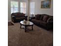 Living room featuring brown sofas, a coffee table, and carpeted floors at 10319 Boyette Creek Blvd, Riverview, FL 33569