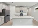 Modern kitchen with island, stainless steel appliances, and white cabinets at 3716 Maxwell Park Dr, Sun City Center, FL 33573