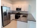 Well-lit kitchen featuring stainless steel appliances, granite countertops, and white cabinetry for a modern, clean aesthetic at 32139 Spiceberry St, San Antonio, FL 33576