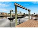 View of modern boat lift and dock overlooking calm canal at 1011 Spindle Palm Way, Apollo Beach, FL 33572