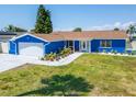 Charming single-story home with white trim, blue siding, manicured lawn, and attached garage at 1011 Spindle Palm Way, Apollo Beach, FL 33572