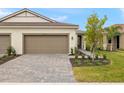 New construction home exterior, featuring a two-car garage and a manicured lawn at 20375 Symphony Pl, Venice, FL 34293