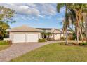 House exterior showcasing a two-car garage and well-manicured lawn at 411 Belle Isle Ave, Belleair Beach, FL 33786