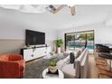 Bright living room with sliding glass doors leading to a screened pool at 2233 Curlew Rd, Dunedin, FL 34698