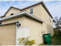 Side view of a beige two-story house with an attached garage at 32111 Brookstone Dr, Wesley Chapel, FL 33545