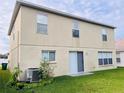 Back of house showing sliding glass doors and a grassy yard at 32111 Brookstone Dr, Wesley Chapel, FL 33545