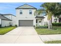 Two-story house with gray siding, two-car garage, and landscaped yard at 3873 Gainer Spring Avenue, New Port Richey, FL 34653