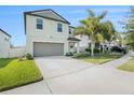Two-story house with gray siding, two-car garage, and landscaped yard at 3873 Gainer Spring Avenue, New Port Richey, FL 34653