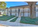 Two-story building with manicured landscaping and a large tree in front at 809 Russell Ln # 323, Brandon, FL 33510