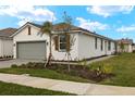 White house with gray garage door, brown shutters, and a paved driveway at 12310 Hearts Ease St, Venice, FL 34293