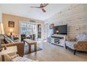 Bright living room with wood-look floors and access to a balcony at 1435 Millstream Ln # 202, Dunedin, FL 34698