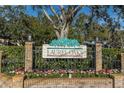 Community entrance sign with brick pillars and flowers at 1510 Mahogany Ln # 606, Palm Harbor, FL 34683