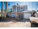 Two-story home featuring a garage, well-maintained landscaping, and neutral paint scheme at 807 Bay Point Dr, Madeira Beach, FL 33708