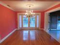 Dining room with hardwood floors, French doors, and a chandelier at 8201 Sunny Vale Pl, Tampa, FL 33615