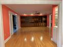 Spacious living room with hardwood floors, built-in shelving, and coral walls at 8201 Sunny Vale Pl, Tampa, FL 33615