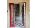 Front entry with red door and staircase leading upstairs at 844 Callista Cay Loop, Tarpon Springs, FL 34689