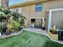 Private backyard with artificial turf, sliding glass door access, and landscaping at 16543 Lake Brigadoon Cir, Tampa, FL 33618