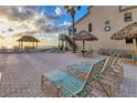 Beachfront patio with lounge chairs and thatched umbrellas offers relaxing ocean views at 4621 Gulf Of Mexico Dr # D10, Longboat Key, FL 34228