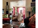 Bright dining area with a round table and four chairs, featuring red curtains and unique decor at 3246 Prescott N St, St Petersburg, FL 33713