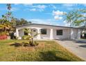 Newly renovated home with white exterior, landscaping, and driveway at 6318 S Renellie Ct, Tampa, FL 33616